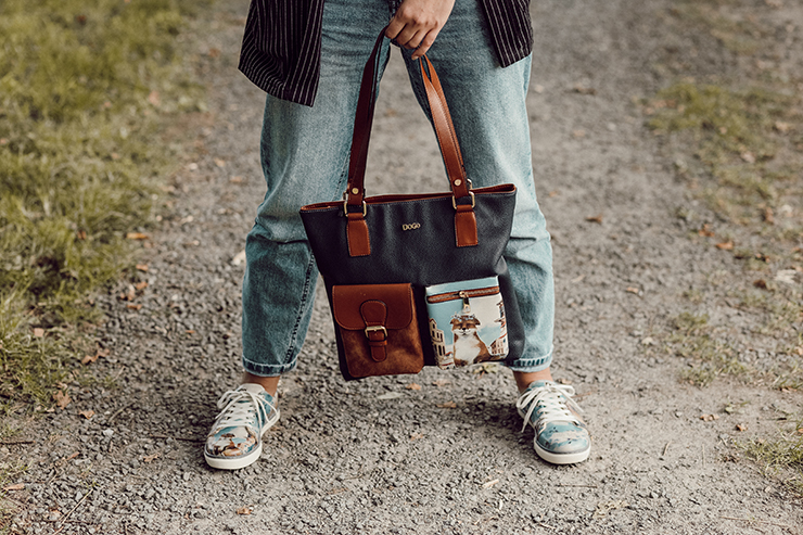 Frau trägt ein Bundle aus Sneakern und Multi Pocket Bag, das einen Fuchs in einer mediterranen Ortschaft zeigt