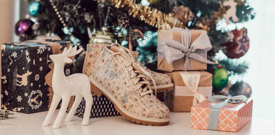 DOGO Short Boots stehen vor einem geschmückten Tannenbaum und Geschenken