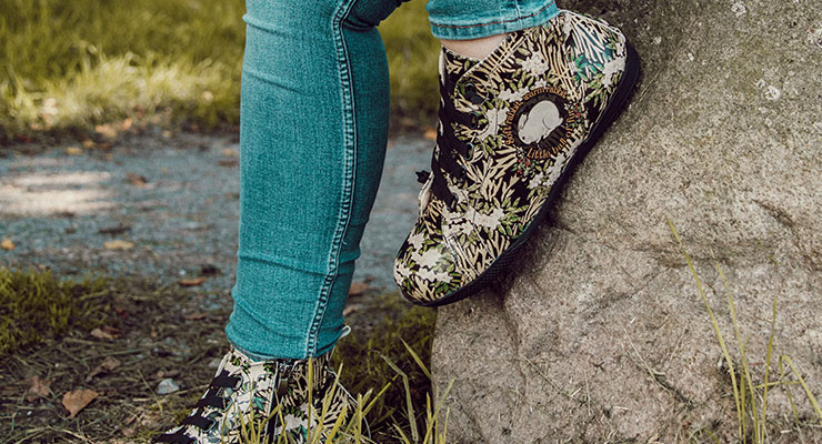 Tierfreunde werden das Design "Little Ball of Fur" des Wonka High-Sneakers für Damen lieben. Frau mit den DOGO High-Sneakern Damen auf einem Stein.