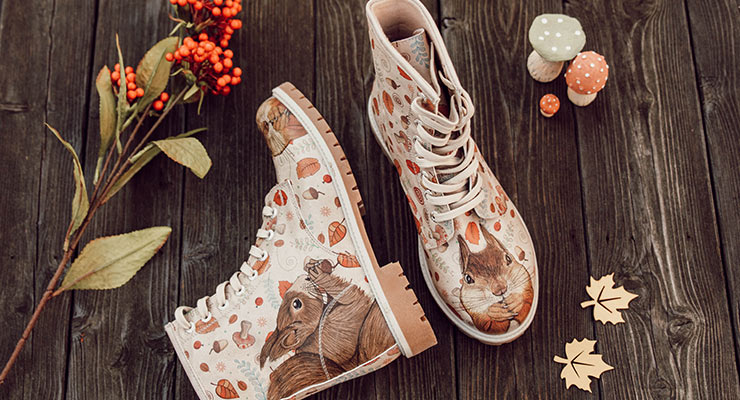 Was wäre eine Bestseller-Liste ohne unseren Long Boot "Squirrel"? Boots mit einem Motiv aus Eichhörnchen und Blättern liegen in einer herbstlichen Kulisse