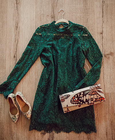 Grünes Spitzenkleid, eine bunte DOGO Clutch und bunte DOGO Pumps auf dem Boden als Outfitinspiration